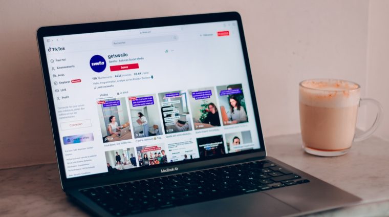 a laptop computer sitting on top of a table next to a cup of coffee